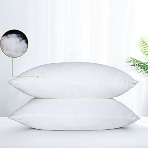 Two fluffy white pillows stacked with close-up of material.