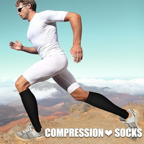 Man running in white athletic gear and black compression socks on a trail